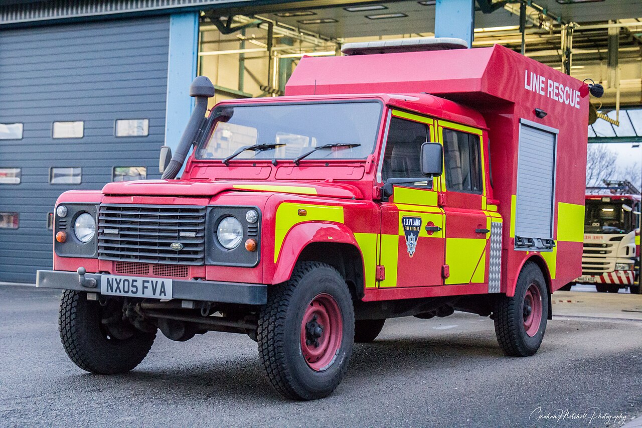 Cleveland Fire Brigade — The same Line Rescue Defender on the station forecourt, showing the roller-shutter box body and yellow high-visibility panelling